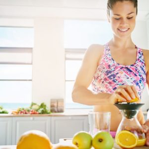 Smiling sporty lady making orange juice