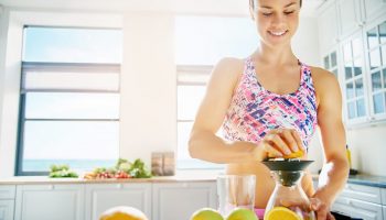 Smiling sporty lady making orange juice
